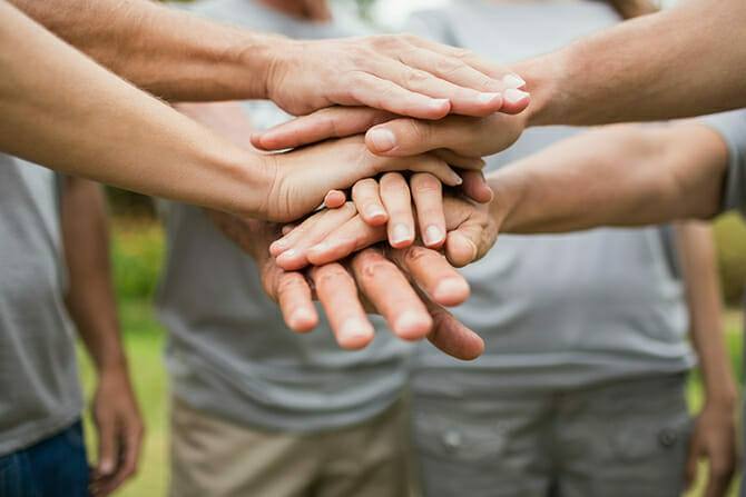 Erlebnispädagogik Ausbildung - Menschen legen Händ übreinandenr