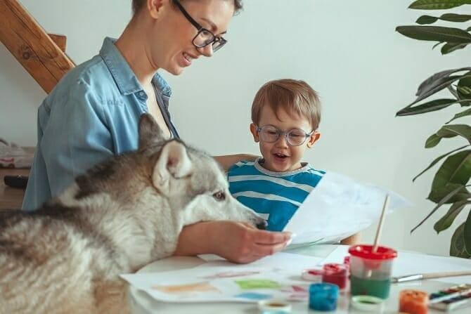 Therapiebegleithunde Trainer Ausbildung - Mutter und Sohn malen in Anwesenheit eines Hundes ein Bild