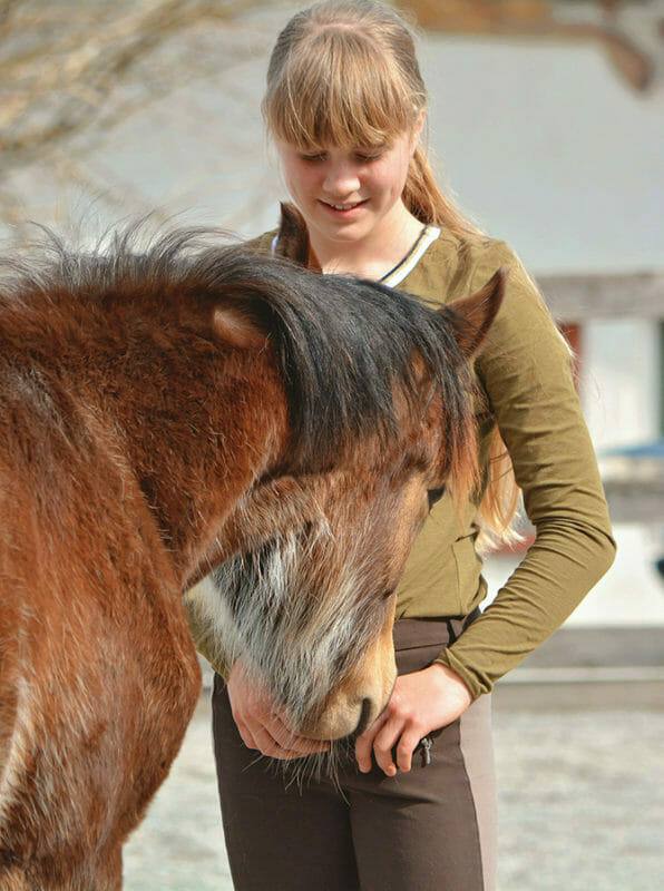Pferdeverhaltensberater Ausbildung - Fohlen schnuppert an junger Frau