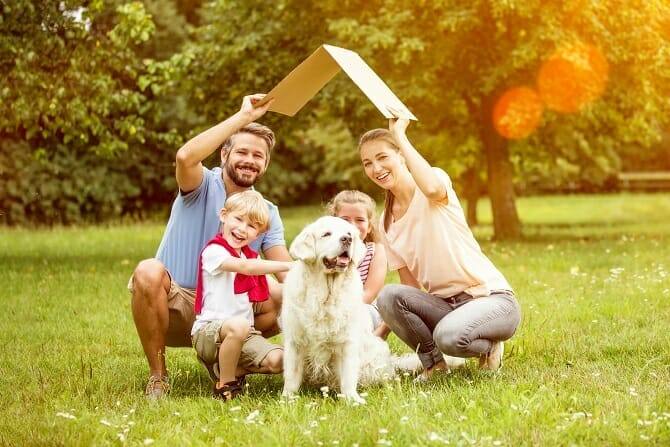 Psychologischer Coach Mensch Tier Beziehung Ausbildung - Junge Familie mit Hund mit Dach über dem Kopf als Symbol für Hausbau